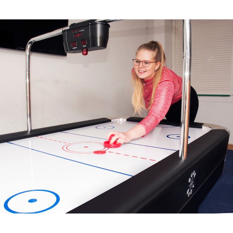 girl playing air hockey table